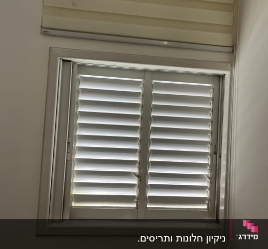 חלון עם תריסים סגורים ותריס גלילה
